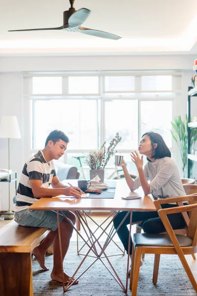 Genç bir sabah kahvelerini birlikte sabah işe gitmeden zevk Malay evli. Bir başkasına kahve onların rahat düz birlikte konuşuyorlar.