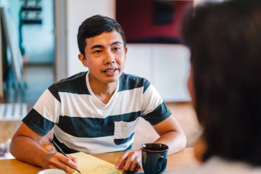 Genç bir sabah kahvelerini birlikte sabah işe gitmeden zevk Malay evli. Bir başkasına kahve onların rahat düz birlikte konuşuyorlar.