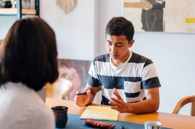Genç bir sabah kahvelerini birlikte sabah işe gitmeden zevk Malay evli. Bir başkasına kahve onların rahat düz birlikte konuşuyorlar.