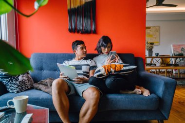 Malay çift kanepede oturup beraber okuduk. Genç, çekici ve rahat onlar onların oturma odasında onların kanepede birlikte hafta sonu zevk gibi olduklarından.