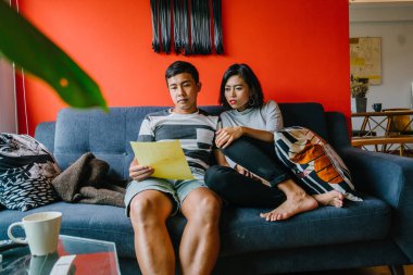 Malay çift kanepede oturup beraber okuduk. Genç, çekici ve rahat onlar onların oturma odasında onların kanepede birlikte hafta sonu zevk gibi olduklarından.