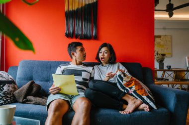 Malay çift kanepede oturup beraber okuduk. Genç, çekici ve rahat onlar onların oturma odasında onların kanepede birlikte hafta sonu zevk gibi olduklarından.