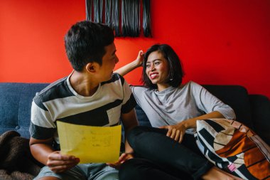 Malay çift kanepede oturup beraber okuduk. Genç, çekici ve rahat onlar onların oturma odasında onların kanepede birlikte hafta sonu zevk gibi olduklarından.