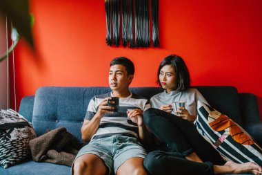 evli Malay çift birlikte modaya uygun ve modern oturma odasında onların kanepede oturup