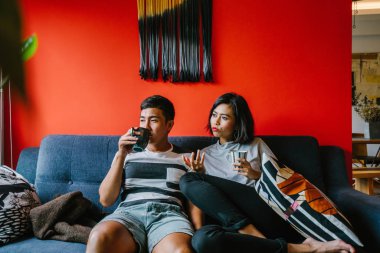 evli Malay çift birlikte modaya uygun ve modern oturma odasında onların kanepede oturup