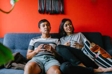 evli Malay çift birlikte modaya uygun ve modern oturma odasında onların kanepede oturup