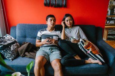 evli Malay çift birlikte modaya uygun ve modern oturma odasında onların kanepede oturup