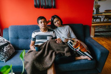 evli Malay çift birlikte modaya uygun ve modern oturma odasında onların kanepede oturup