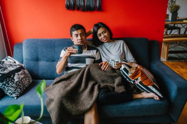 evli Malay çift birlikte modaya uygun ve modern oturma odasında onların kanepede oturup