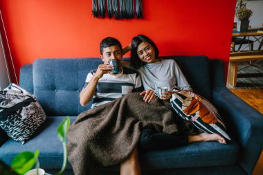 evli Malay çift birlikte modaya uygun ve modern oturma odasında onların kanepede oturup