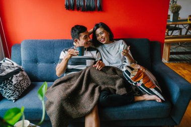 evli Malay çift birlikte modaya uygun ve modern oturma odasında onların kanepede oturup