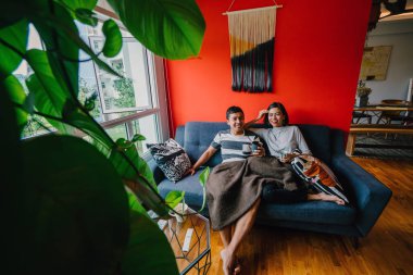 evli Malay çift birlikte modaya uygun ve modern oturma odasında onların kanepede oturup