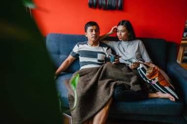 evli Malay çift birlikte modaya uygun ve modern oturma odasında onların kanepede oturup
