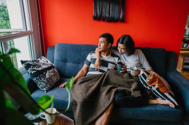 evli Malay çift birlikte modaya uygun ve modern oturma odasında onların kanepede oturup