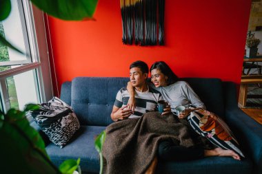 evli Malay çift birlikte modaya uygun ve modern oturma odasında onların kanepede oturup