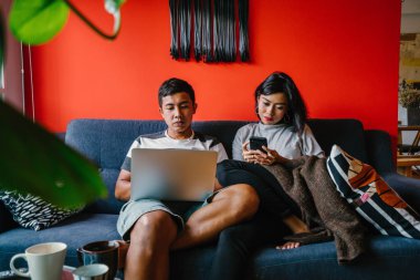 Genç Malay evli çift hafta sonları evde otur. Adam kendi dizüstü bilgisayarında çalışıyor ve onun karısı onun smartphone denetliyor