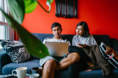 Genç Malay evli çift hafta sonları evde otur. Adam kendi dizüstü bilgisayarında çalışıyor ve onun karısı onun smartphone denetliyor