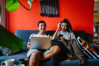 Genç Malay evli çift hafta sonları evde otur. Adam kendi dizüstü bilgisayarında çalışıyor ve onun karısı onun smartphone denetliyor