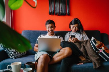 Genç Malay evli çift hafta sonları evde otur. Adam kendi dizüstü bilgisayarında çalışıyor ve onun karısı onun smartphone denetliyor