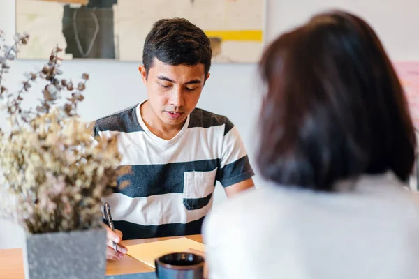 Genç bir sabah kahvelerini birlikte sabah işe gitmeden zevk Malay evli. Bir başkasına kahve onların rahat düz birlikte konuşuyorlar.