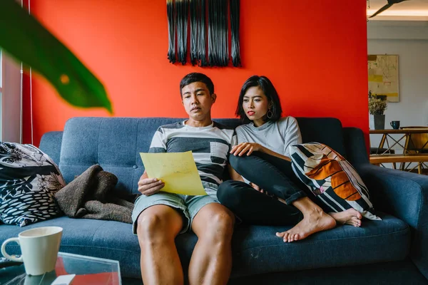 Malay çift kanepede oturup beraber okuduk. Genç, çekici ve rahat onlar onların oturma odasında onların kanepede birlikte hafta sonu zevk gibi olduklarından.