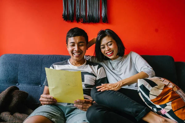 Malay çift kanepede oturup beraber okuduk. Genç, çekici ve rahat onlar onların oturma odasında onların kanepede birlikte hafta sonu zevk gibi olduklarından.