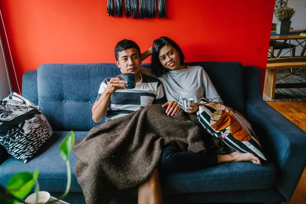 evli Malay çift birlikte modaya uygun ve modern oturma odasında onların kanepede oturup