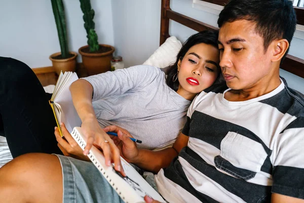 Tembel hafta sonu yatakta oturup bir genç ve çekici Malay Asya çift portresi. 