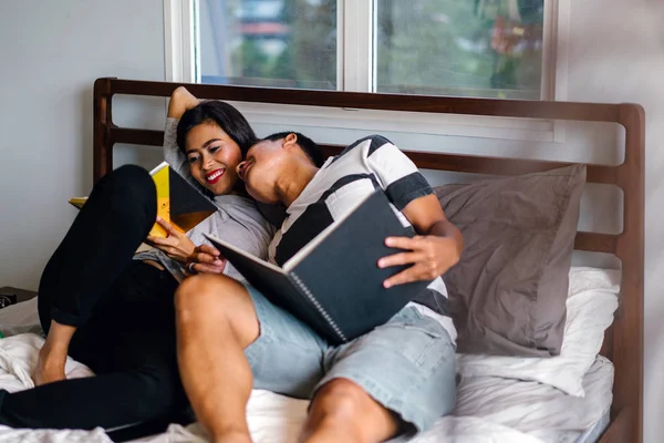 Tembel hafta sonu yatakta oturup bir genç ve çekici Malay Asya çift portresi. 