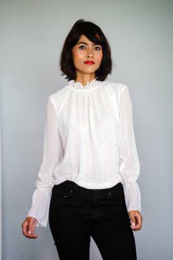 Beyaz gömlek ve siyah pantolon beyaz bir arka plan karşı bir genç, uzun boylu ve ince Malay kadın portresi