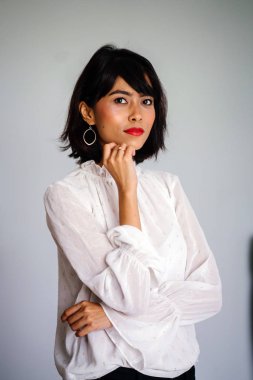 Beyaz gömlek ve siyah pantolon beyaz bir arka plan karşı bir genç, uzun boylu ve ince Malay kadın portresi