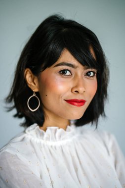 Beyaz gömlek ve siyah pantolon beyaz bir arka plan karşı bir genç, uzun boylu ve ince Malay kadın portresi