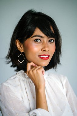 Beyaz gömlek ve siyah pantolon beyaz bir arka plan karşı bir genç, uzun boylu ve ince Malay kadın portresi