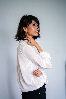Beyaz gömlek ve siyah pantolon beyaz bir arka plan karşı bir genç, uzun boylu ve ince Malay kadın portresi