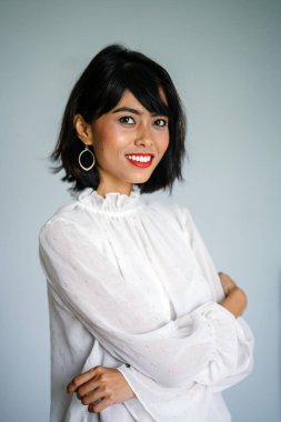 Beyaz gömlek ve siyah pantolon beyaz bir arka plan karşı bir genç, uzun boylu ve ince Malay kadın portresi