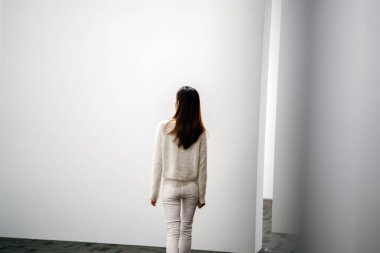 Genç bir kadın pencerenin yanında gözleri kapalı duruyor.