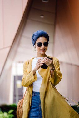 Genç ve çekici Malay Müslüman kadın gündüz elele smartphone