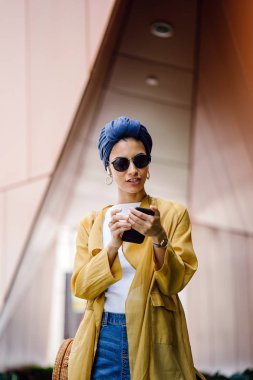 Genç ve çekici Malay Müslüman kadın gündüz elele smartphone