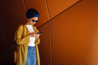 Genç ve çekici Malay Müslüman kadın smartphone elinde tutan 