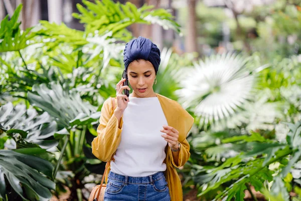 若くて魅力的なマレーのネーチャンの手順を歩いて 日中彼女のスマート フォンの話 — ストック写真