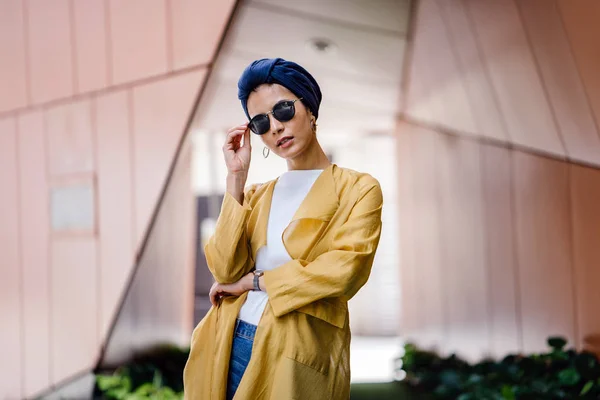 Fashion portrait of a tall, slim, young and attractive Malay Muslim woman wearing fashionable clothing and a turban