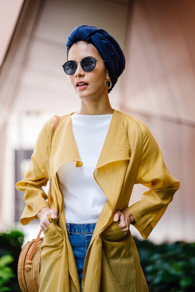 Fashion portrait of a tall, slim, young and attractive Malay Muslim woman wearing fashionable clothing and a turban