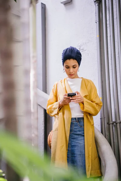 Genç ve çekici Malay Müslüman kadın smartphone elinde tutan 