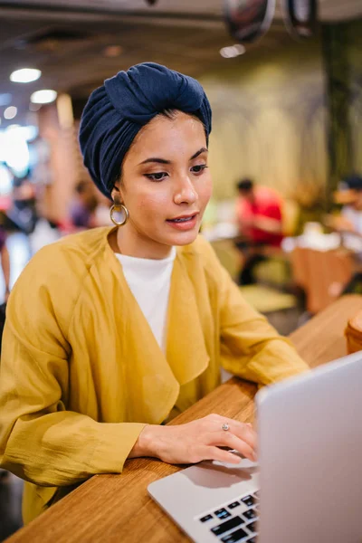 一个年轻的穆斯林马来妇女工作或学习在她的笔记本电脑室内的肖像 她穿着时髦的蜡笔服装和头巾 头围巾 — 图库照片