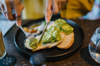 Peynirli ve sebzeli sandviç yiyen kadına yakın durun. 