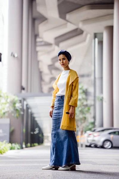 Fashion portrait of a tall, slim, young and attractive Malay Muslim woman wearing fashionable clothing and a turban