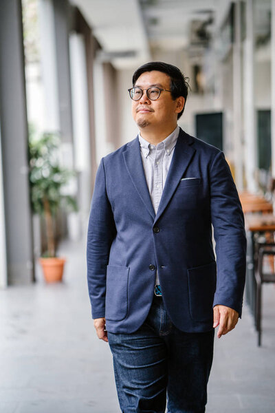 Портрет китайского азиата средних лет в повседневном костюме (рубашка, куртка). Он носит очки и выглядит стильно, умно, образованно и уверенно
.