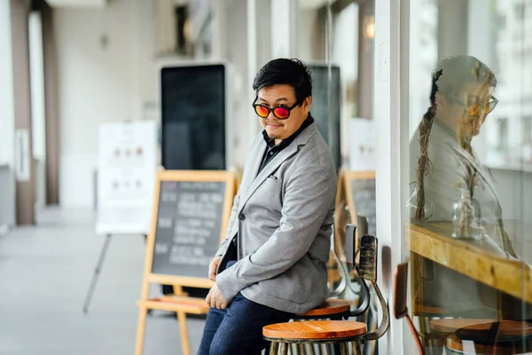 portrait of a Chinese Asian man in a grey suit, black shirt and sunglasses (smart casual). He is confident, cool and handsome in his smart casual outfit