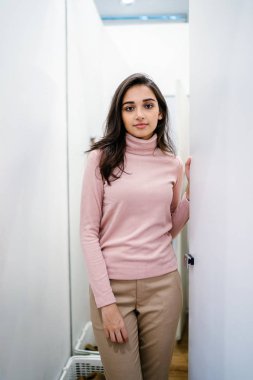 Yeni giyim moda salonu bir alışveriş merkezinde bir montaj odasında çalışıyor bir genç ve güzel Hint Asyalı kadın portresi.