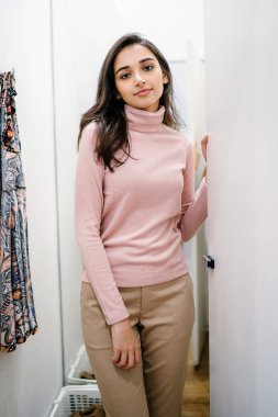 Yeni giyim moda salonu bir alışveriş merkezinde bir montaj odasında çalışıyor bir genç ve güzel Hint Asyalı kadın portresi.